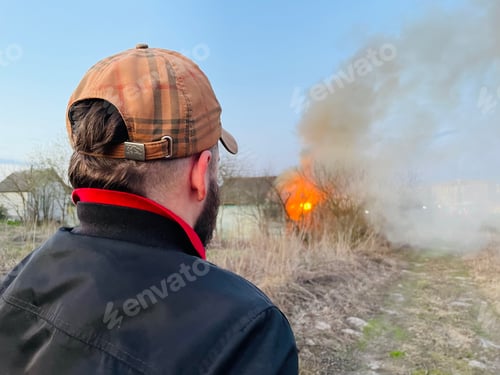 Preview: Photo of a man against the background of a burning house