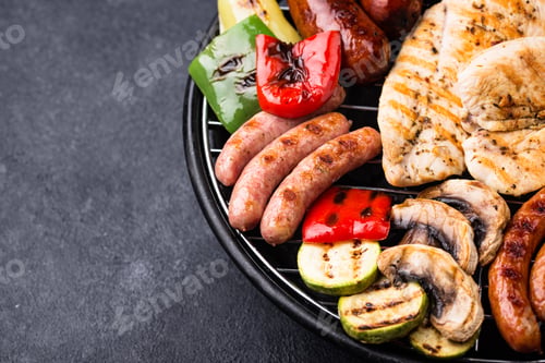 Vista previa: Grilled sausages, meat, and vegetables.