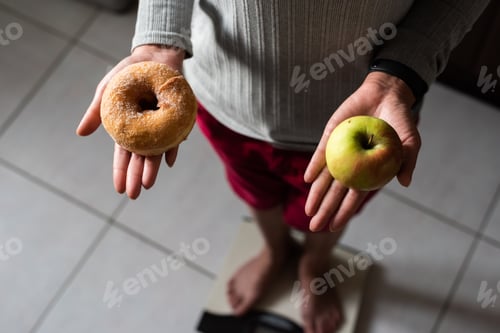 Preview: Woman Hold An Apple And Donuts And Stand On Scale At Home, Concept Of Healthy