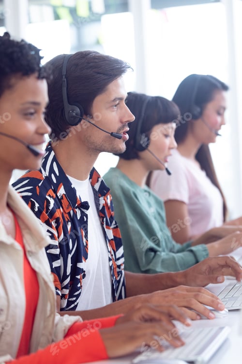 Preview: Side view of diverse customer service executives working on computer at desk in office