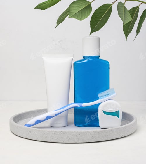 Preview: Refreshing mouthwash in a transparent plastic bottle and dental floss on a white background