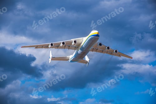 Preview: A large cargo plane flies in the blue sky. Aviation air transport. Airplane symbol.