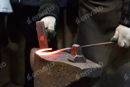 Preview: blacksmith in the workshop making horseshoes