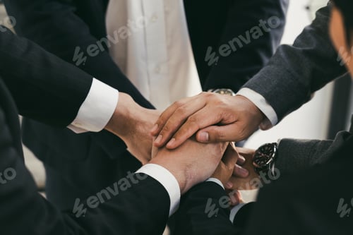 Preview: Close up of group of business people joining their hands together in unity.