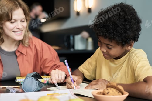 Preview: Smiling Female Teacher Helping Boy with Homework