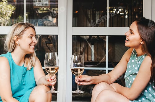 Preview: Two adult women with wineglasses in sunlight
