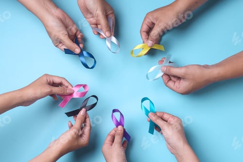 Preview: Multi-color ribbons on hands isolated on blue. Cancer awareness, World cancer day.