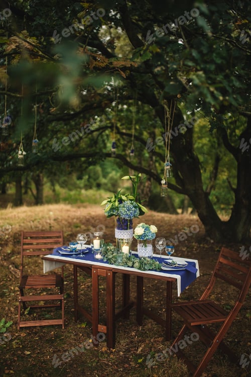 Preview: Decor. Details. Wedding decorations. On the wooden table in the woods there is a flower arrangement