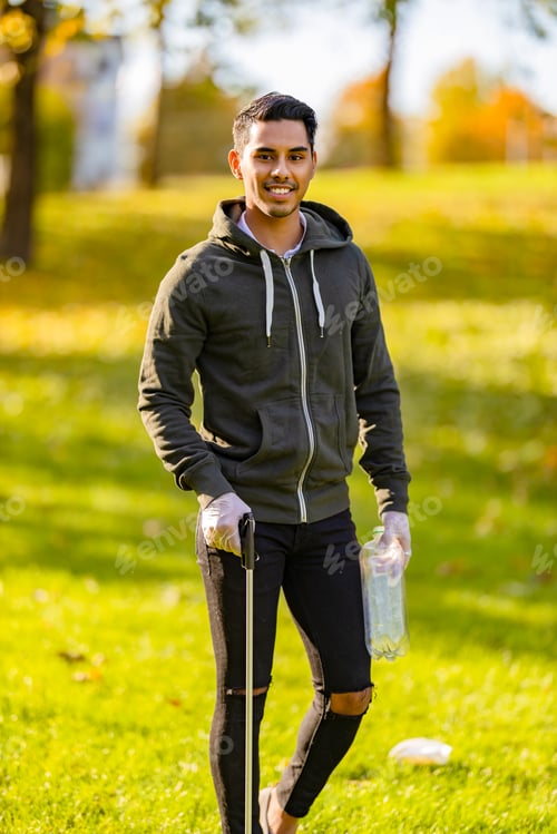 Preview: Confident volunteer cleaning park environment on sunny day