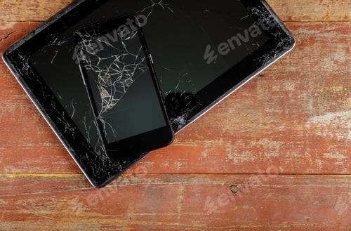 Preview: Tablet computer and smart phone with broken glass screen on the wood background