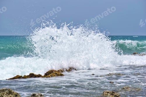 Preview: Beautiful crashing large ocean wave smashing on a rocky coastline shore while traveling on vacation