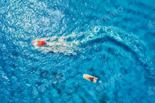 Preview: Aerial view of floating motorboat in transparent blue sea