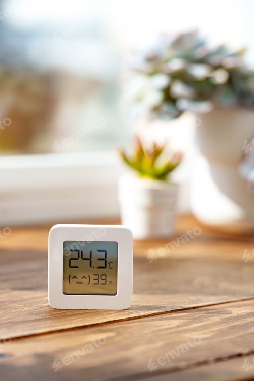 Preview: Digital Thermometer Displaying Temperature and Humidity Near Window