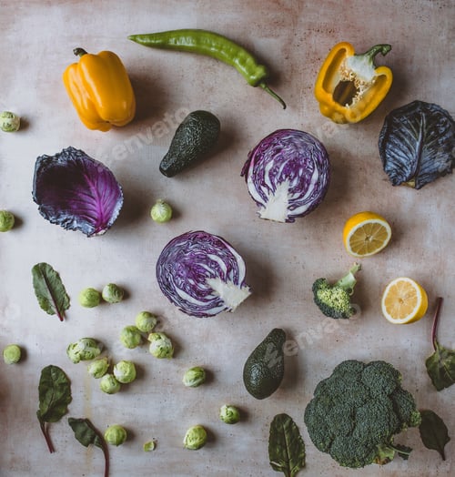 Preview: top view of red cabbage, peppers, avocados, lemon, broccoli, brussel sprouts and leaves on table