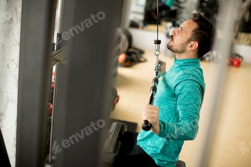 Preview: Man doing excersise on a lat machine in gym