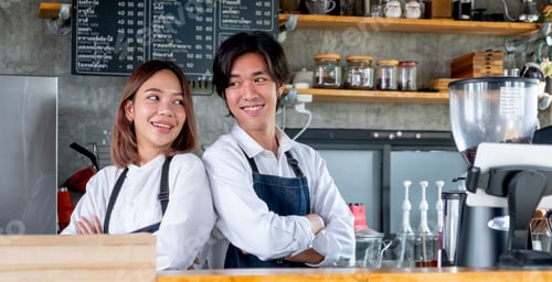 Preview: Two Asian barista or coffee maker man and woman stand with arm-crossed