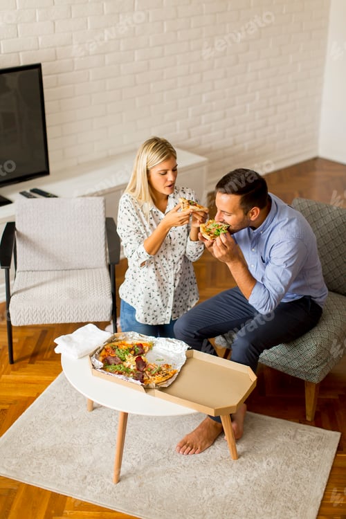 Preview: Couple relaxing at home and eating tasteful pizza
