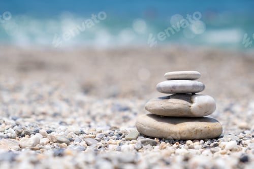 Preview: Round stones lie on top of each other in a column on the seashore