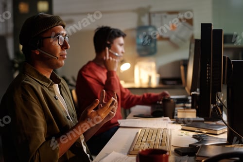 Preview: Young Adult Man Operating Scam Call Center with Colleague Working