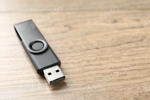 Preview: One flash drive on wooden background, closeup. Space for text