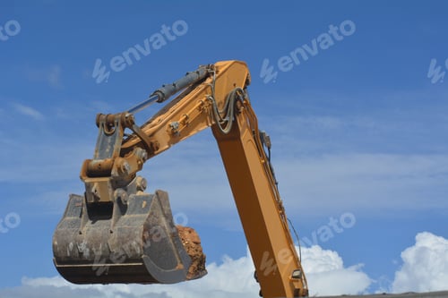 Preview: Excavator bucket backhoe with soil against the blue sky