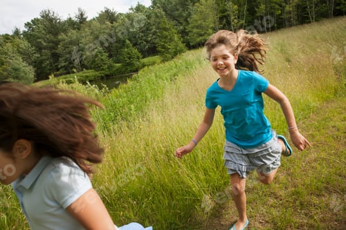 Preview: Two children, girls playing chase and running along a path.