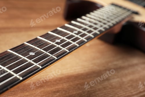 Preview: Modern electric guitar on wooden background, neck with strings in focus
