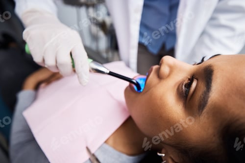 Preview: Shot of a dentist using a curing light on a patient during orthodontic treatment