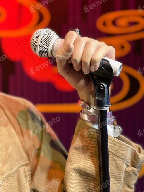 Preview: Singer holding microphone - closeup on hand holding the microphone