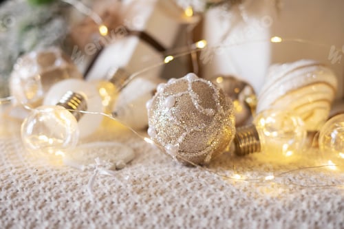 Preview: Light bronze glitter Christmas ball on a beige knitted plaid and Christmas decorations.