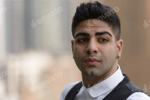 Preview: Portrait of young handsome Indian businessman in the city