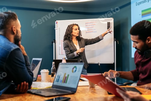 Preview: Business woman leading a meeting analyzing company data in a coworking space