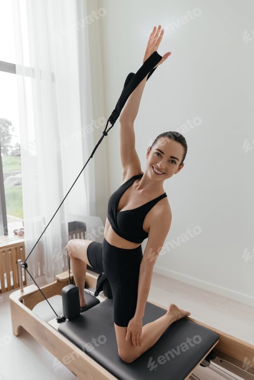 Preview: Pilates reformer training machine. sporty woman exercising gym