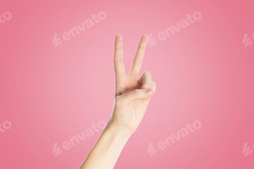 Preview: Positive gesture on a pink background. Hand show viktory sign, close up