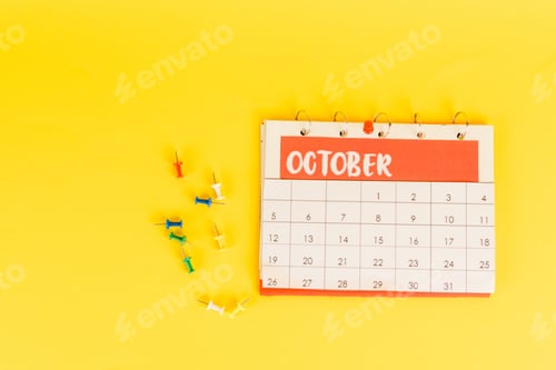 Preview: Top view of calendar with october month and office pins on yellow background