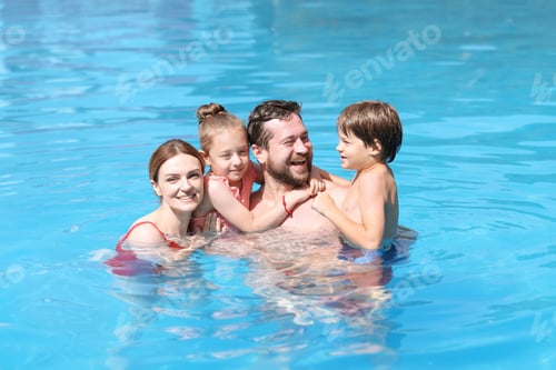 Preview: Happy family resting in swimming pool outdoors