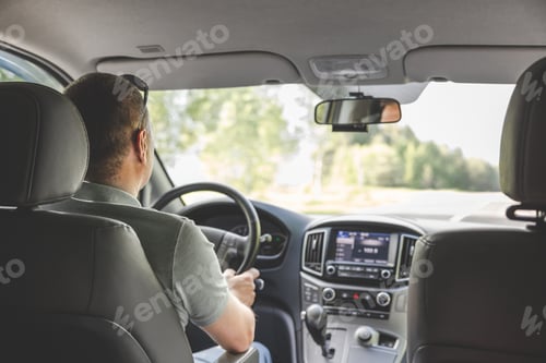 Preview: Young man holding steering wheel while driving car. Road trip adventure