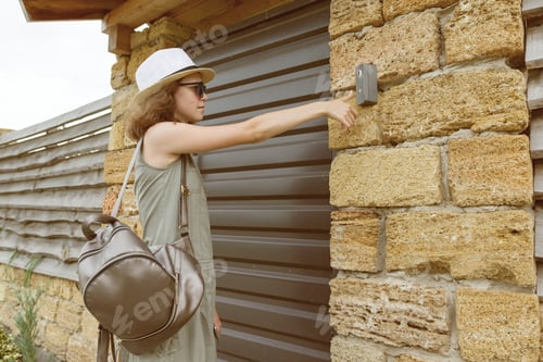 Preview: Outdoors girl calls the intercom, standing near the front door