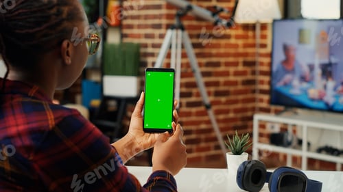 Preview: African american woman vertically holding telephone with greenscreen