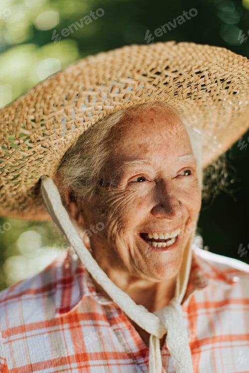 Preview: Portrait of a happy senior woman with a straw hat