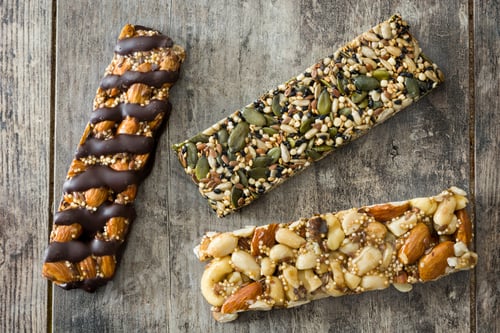 Preview: Protein bars with nuts, seeds, chocolate and dried fruits lying on rustic wooden table