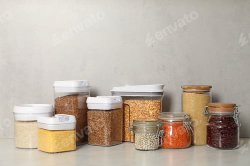 Preview: Different types of cereals and legumes in containers on light marble table
