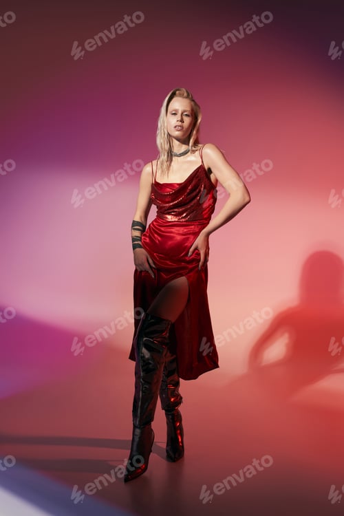 Preview: fashionable sexy woman with tattoo in red stylish dress posing alluringly and looking at camera