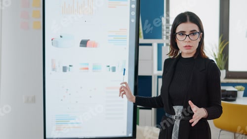 Preview: Woman Presenting Business Charts in a Workplace