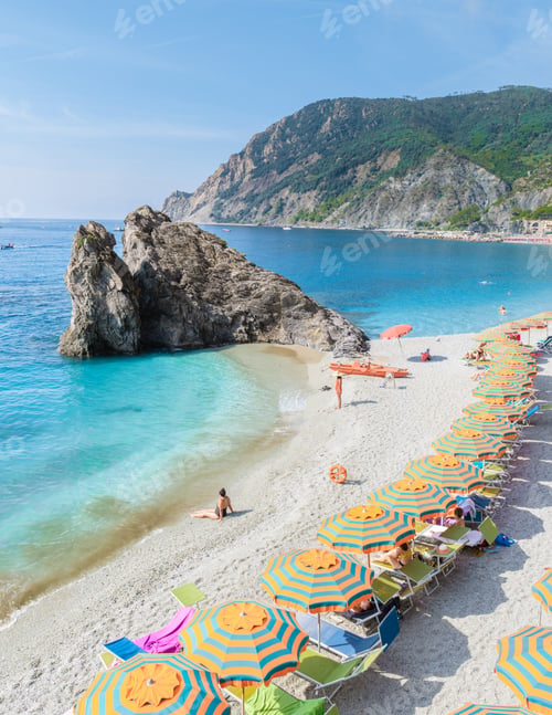 Preview: Pebble beach Monterosso vacation Chairs and umbrellas on the beach of Cinque Terre Italy at summer