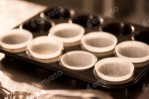 Preview: close up view of empty baking forms with baking paper for cupcakes