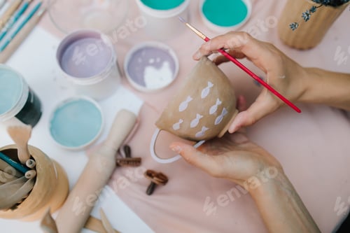 Preview: Top-Down View of Artist Painting Fish Patterns on Ceramic Bowl