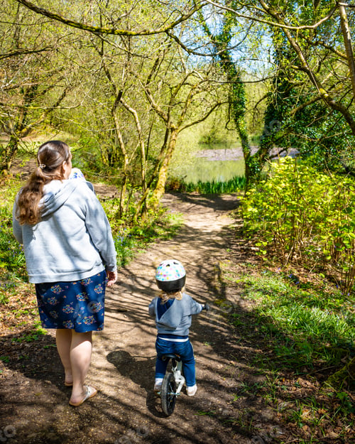 Preview: Mother and toddler on a bike walking and riding on a forest trail