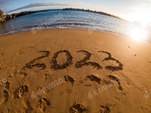Preview: tropical New Year 2023 written in golden sand on the beach