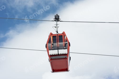 Preview: Close-up of cable car or ski lift cabin with alpine skis moving against the background of cloudy sky